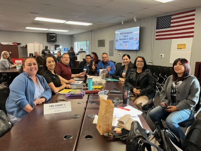 Educators smiling during a PBIS cohort training