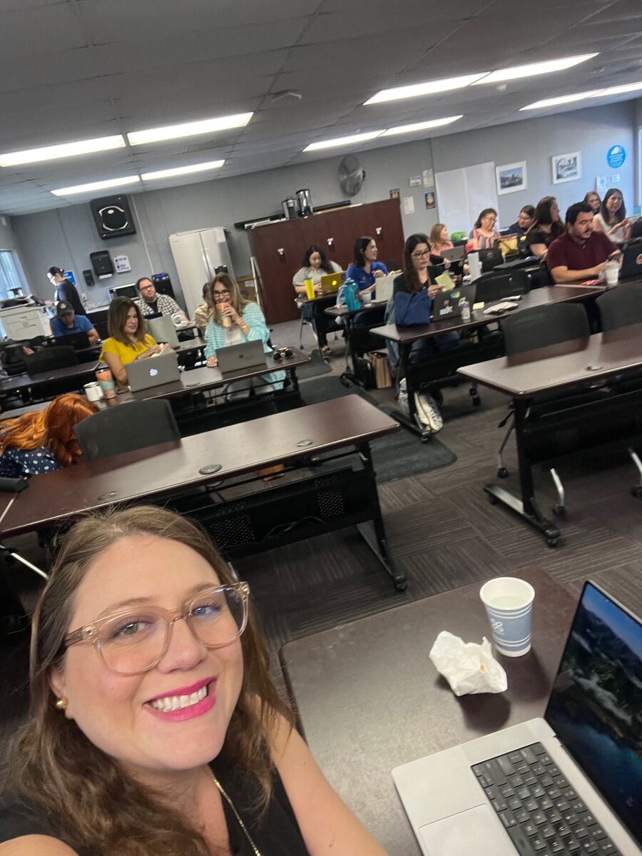 Jessica smiling in front of a full room of educators at a professional learning day